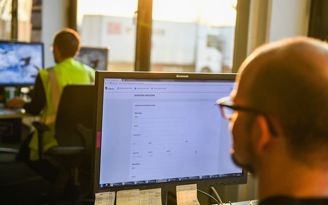 Mann sitzt im Büro vor einem Monitor