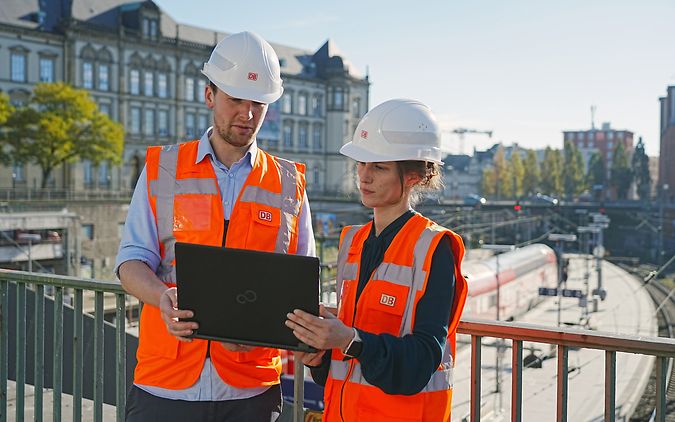 Zwei Bauarbeiter prüfen Laptop